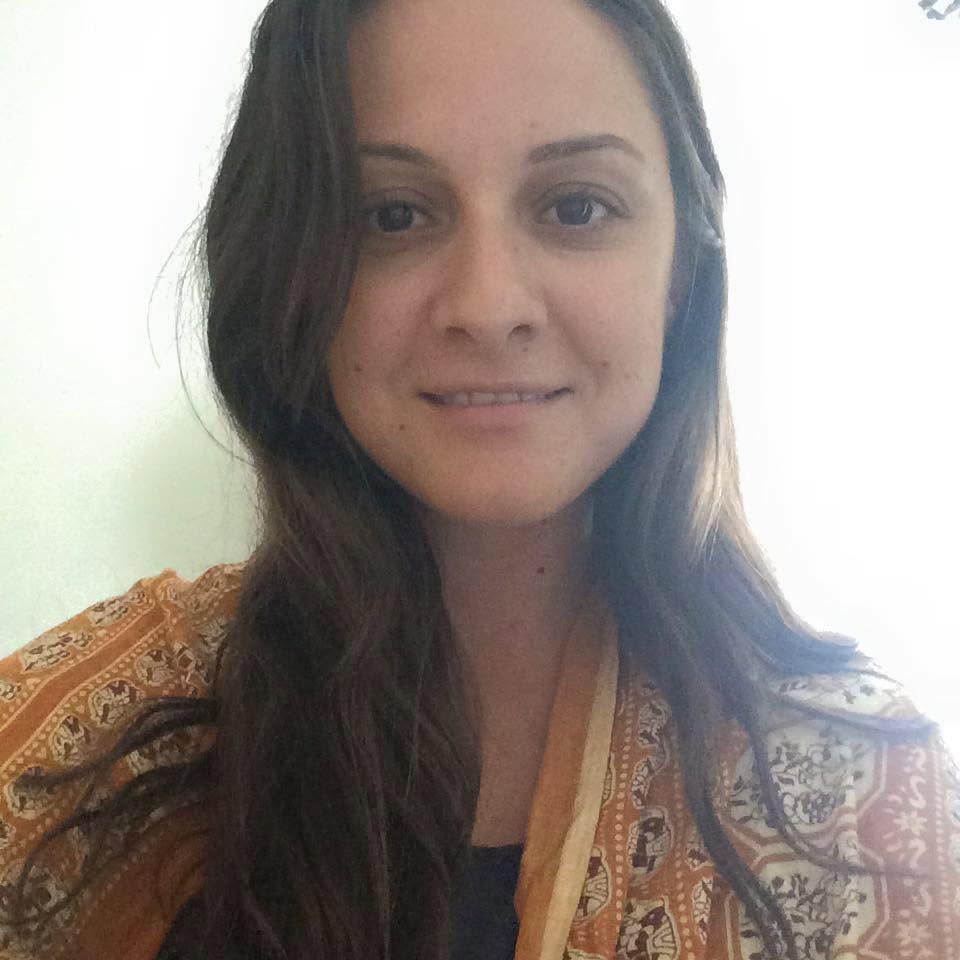 Portrait of Panayiota Bertzikis smiling, wearing a patterned orange scarf